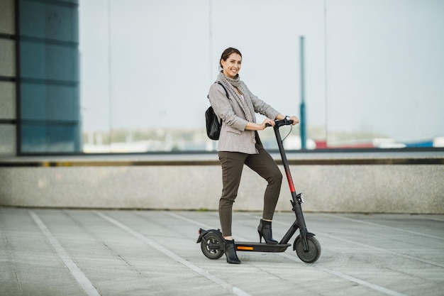 A young businesswoman with an electric push scooter going to work.