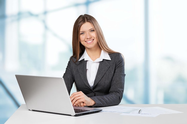 Young businesswoman with laptop smiling at camera