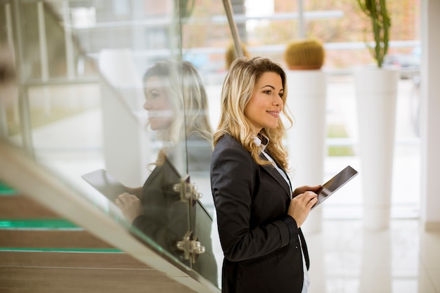 Young businesswoman with tablet in the modern office