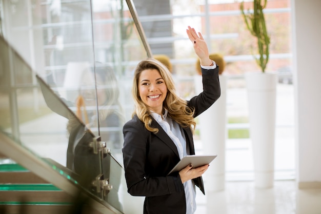 Young businesswoman with tablet in the modern office