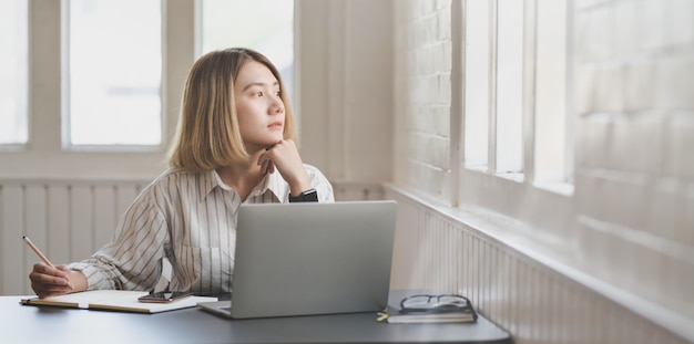 Young businesswoman working on her project and writing on notebook 