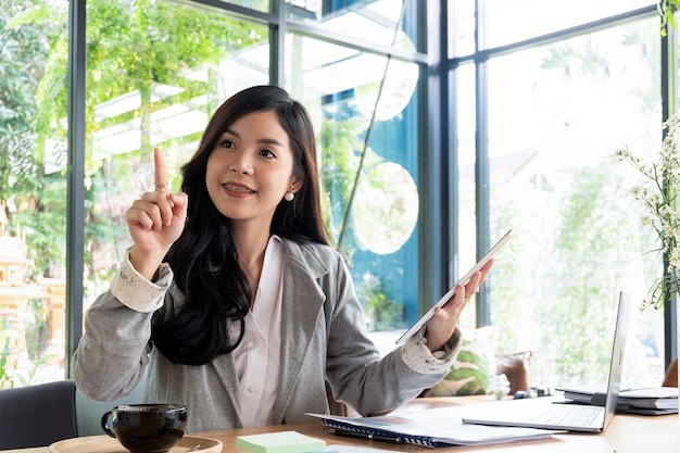 young businesswoman working with laptop documents in office and looking up