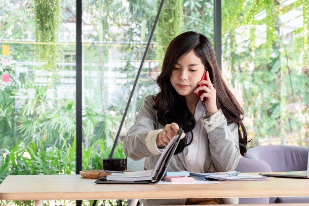 young businesswoman working with mobile laptop and documents in office