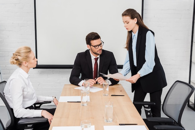 young businesswomen showing documents to their boss at modern office