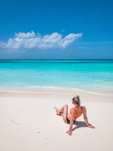 Young carefree woman relaxing on a beautiful exotic beach, seascape, tropical freedom