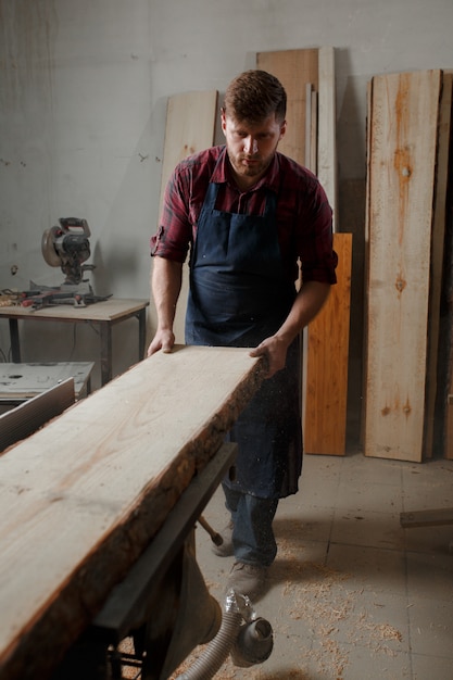 Young carpenter with an apron in his workshop