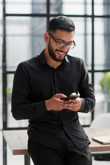 Young casual Businessman holding and using smartphone for sms messages