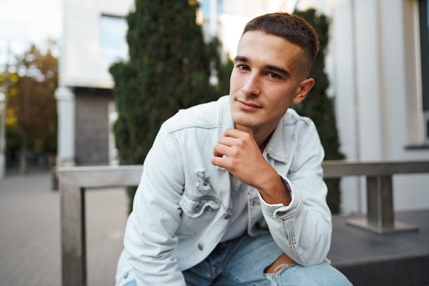 Young casual man sitting on stairs alone on street