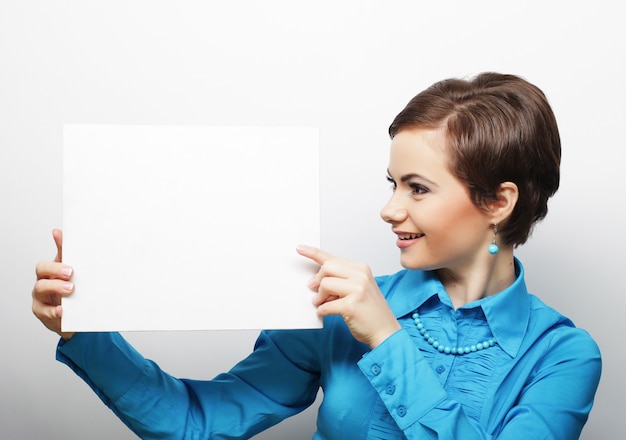 Young casual woman happy holding blank sign 