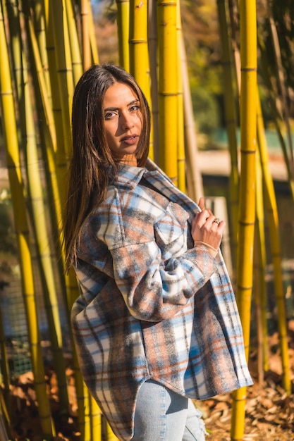 Young caucasian brunette girl in a plaid wool sweater smiling