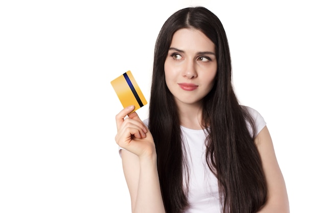 Young caucasian brunette woman in white t shirt demonstrating her gold bank credit card for mock up