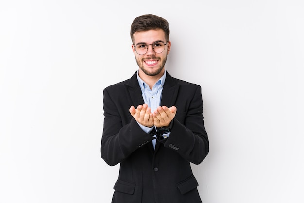 Young caucasian business man posing in a white wall isolated Young caucasian business man holding something with palms,