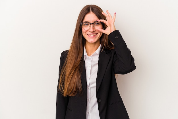 Young caucasian business woman isolated on white background excited keeping ok gesture on eye.