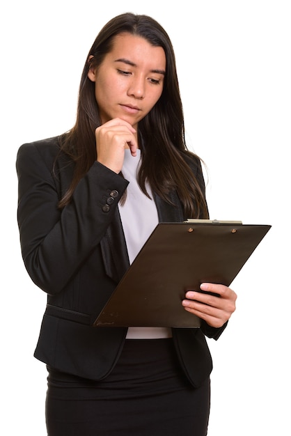 Young Caucasian businesswoman reading on clipboard while thinking