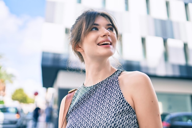 Young caucasian businesswoman smiling happy walking at the city