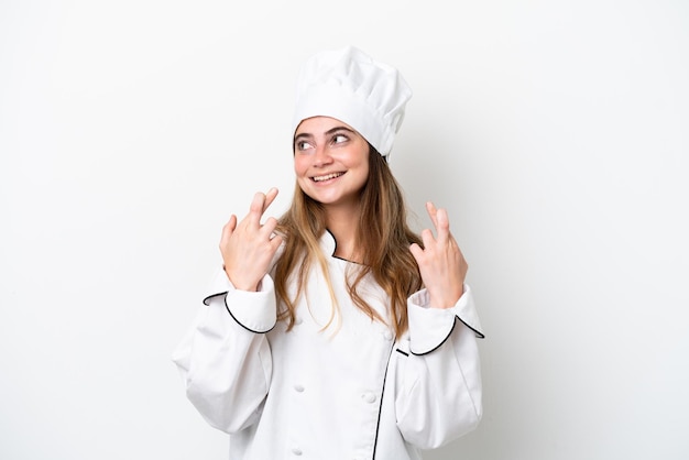 Young caucasian chef woman isolated on white background with fingers crossing