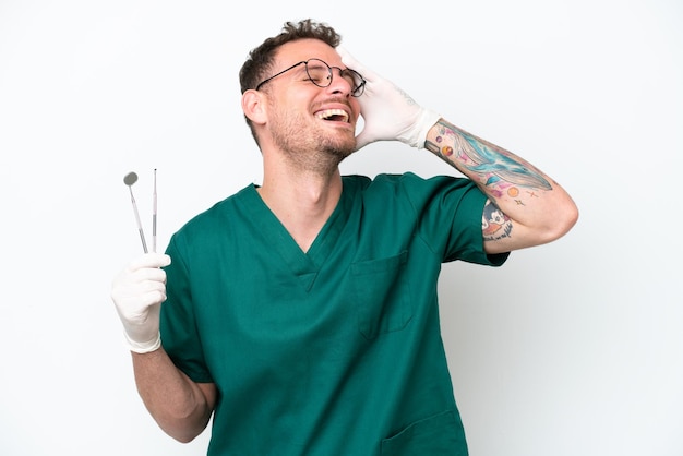 Young caucasian dentist man isolated on white background smiling a lot