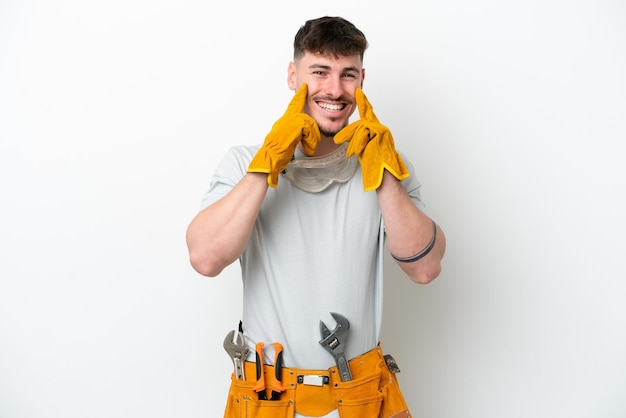 Photo young caucasian electrician man isolated on white background smiling with a happy and pleasant expression