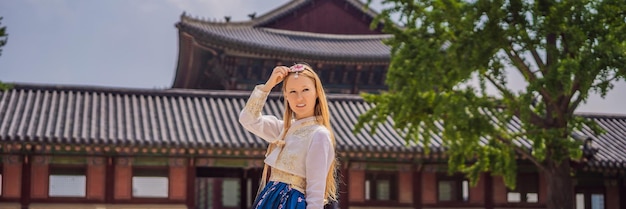 Young caucasian female tourist in hanbok national korean dress Travel to Korea concept National Korean clothing Entertainment for tourists trying on national Korean clothing BANNER LONG FORMAT