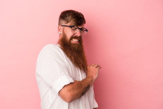 Young caucasian ginger man with long beard isolated on pink background confused, feels doubtful and unsure.