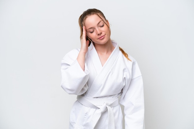 Young caucasian girl doing karate isolated on white background with headache