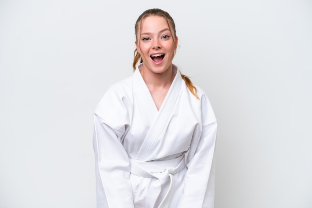 Young caucasian girl doing karate isolated on white background with surprise facial expression