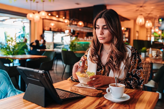 Young Caucasian girl having a healthy breakfast for her diet in a restaurant.