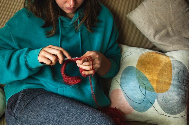 Photo young caucasian girl holding crochet and woolen yarn handmade hobby quiet and relaxing