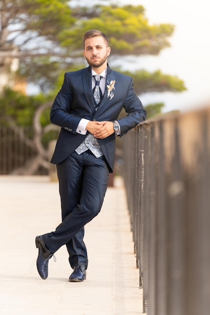 Young caucasian groom with beard looking at the camera Summer outside