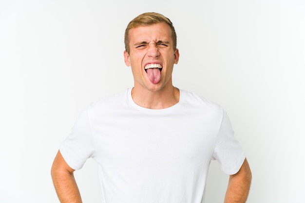 Young caucasian handsome man funny and friendly sticking out tongue.