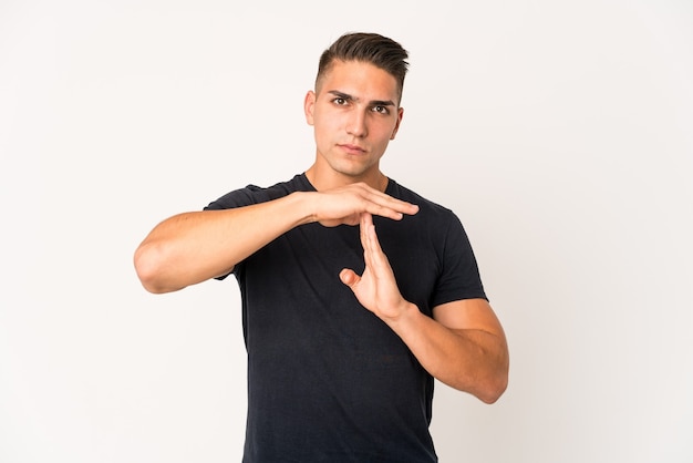 Young caucasian handsome man isolated showing a timeout gesture.