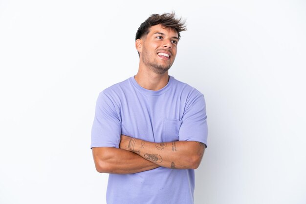 Young caucasian handsome man isolated on white background looking up while smiling