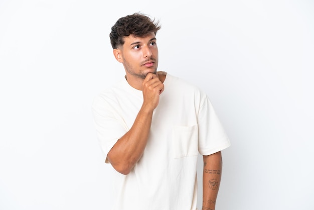 Young caucasian handsome man isolated on white background and looking up