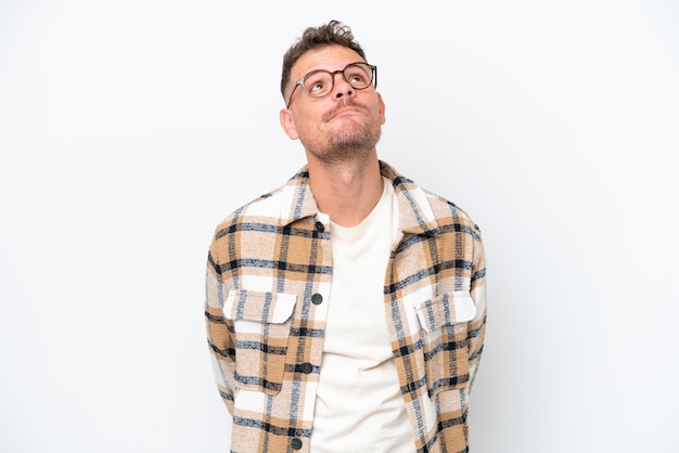 Young caucasian handsome man isolated on white background and looking up