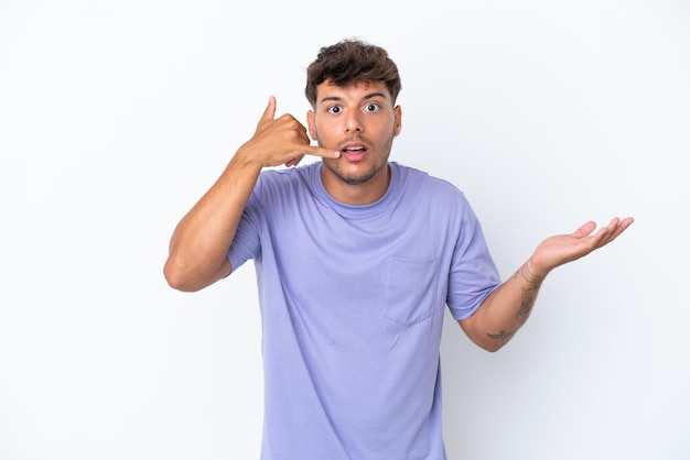 Young caucasian handsome man isolated on white background making phone gesture and doubting