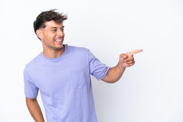 Young caucasian handsome man isolated on white background pointing finger to the side and presenting a product