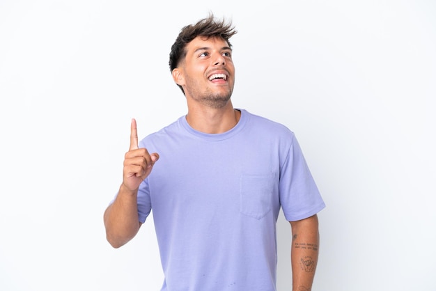 Young caucasian handsome man isolated on white background pointing up and surprised