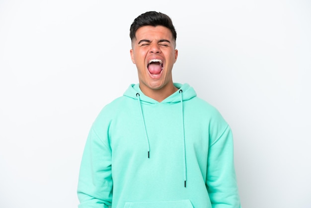 Young caucasian handsome man isolated on white background shouting to the front with mouth wide open