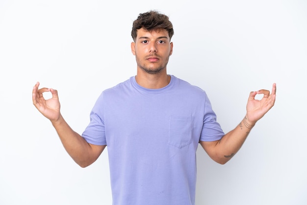 Young caucasian handsome man isolated on white background in zen pose