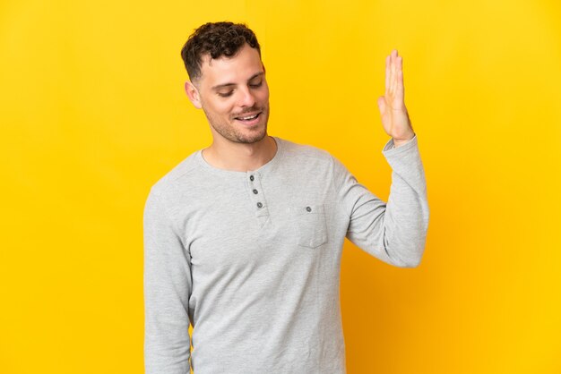 Young caucasian handsome man isolated on yellow with tired and sick expression