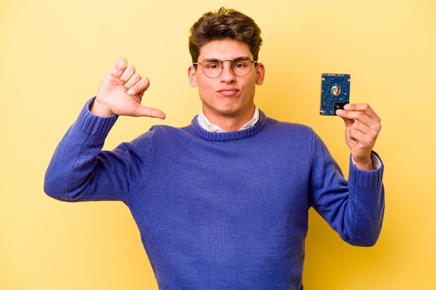 Young caucasian informatics man isolated on yellow background showing a dislike gesture thumbs down Disagreement concept