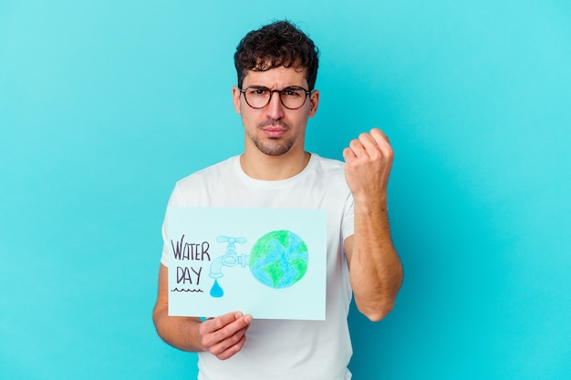 Young caucasian man celebrating world water day isolated showing fist to camera, aggressive facial expression.