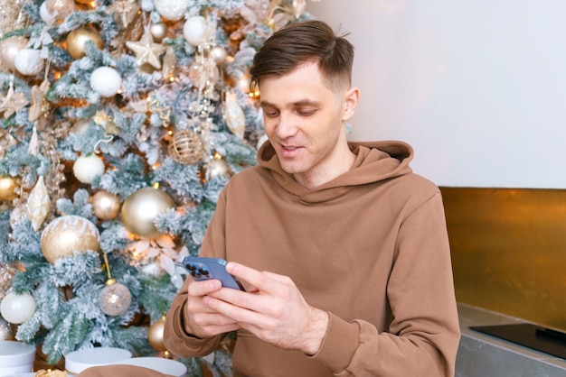 Young caucasian man communicates via video communication using phone in living