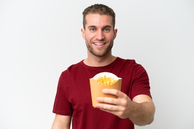 Young caucasian man holding fries potatoes isolated on white background