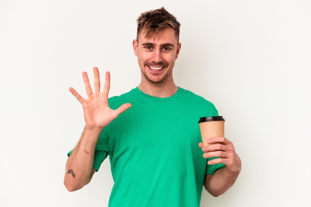 Young caucasian man holding a take away coffee isolated on white background smiling cheerful showing number five with fingers.