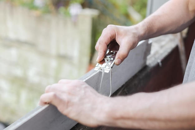 A young caucasian man is repairing a window opening removing the silicone insulation