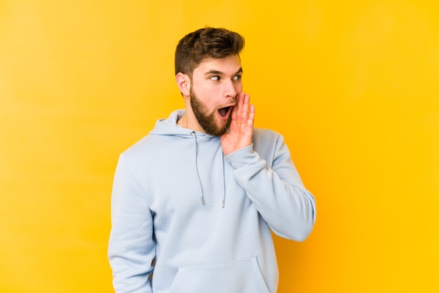 Young caucasian man is saying a secret hot braking news and looking aside