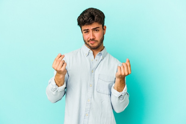 Young caucasian man isolated on blue background showing that she has no money.