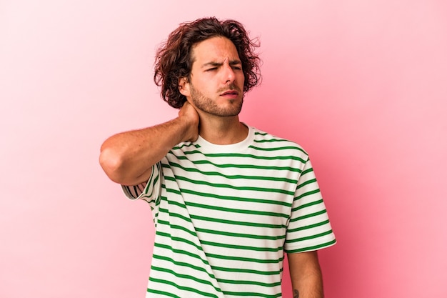 Young caucasian man isolated on pink bakcground touching back of head, thinking and making a choice.