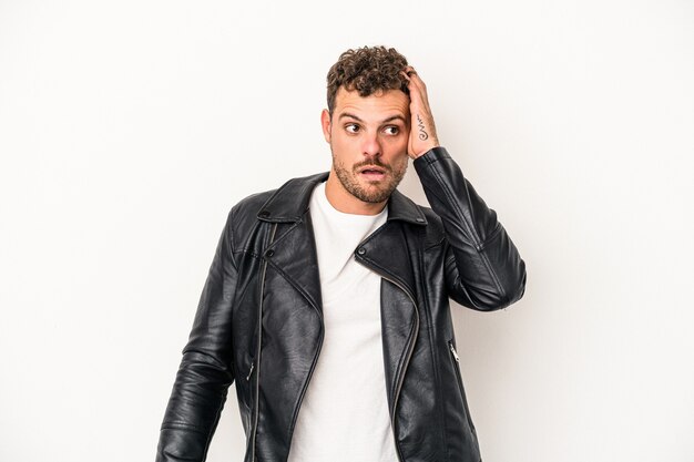 Young caucasian man isolated on white background being shocked, she has remembered important meeting.